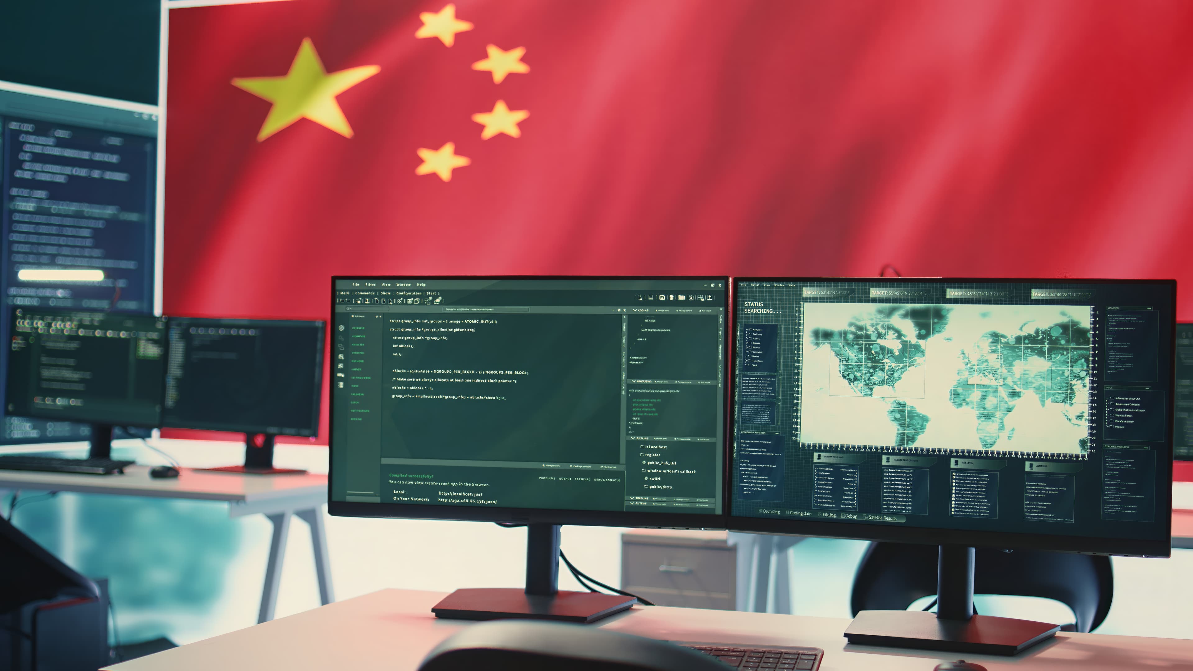Sala com monitores de código e mapa-múndi, e a bandeira da China ao fundo.